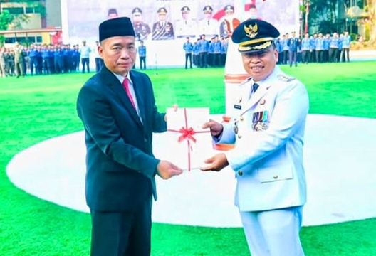 Penyerahan 50 sertipikat Hak Pakai atas nama Pemerintah Kota Depok dari Kepala Kantor Pertanahan Kota Depok Budi Jaya, S.T., M.T., QRMP, kepada Wali Kota Depok Supian Suri dalam rangkaian upacara peringatan HUT ke-81 Kemerdekaan Republik Indonesia di Lapangan Balai Kota Depok, Senin (17/8/2026).